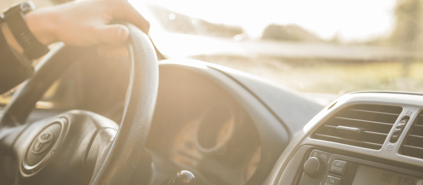 คนกำลังเอามือจับพวงมาลัยรถ