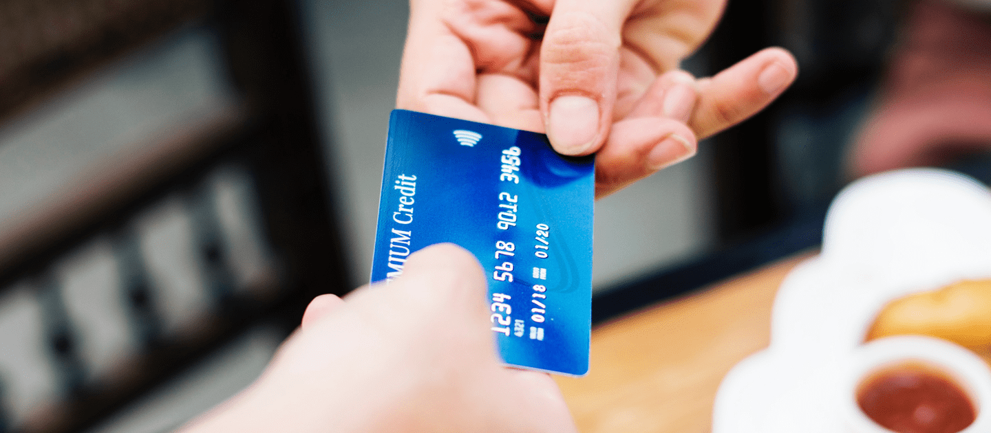 ภาพคนกำลังยื่นบัตรเครดิตสำน้ำเงิน